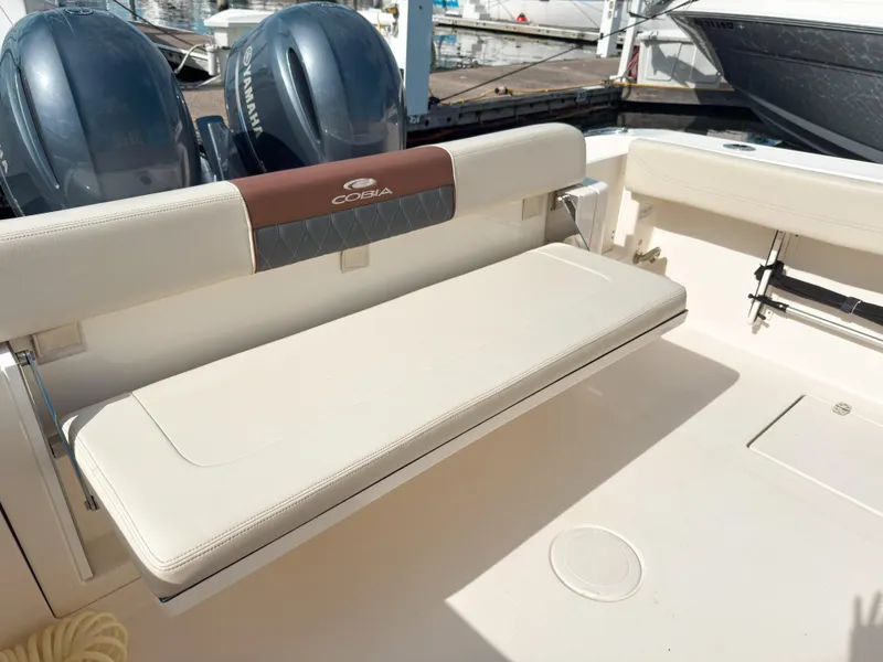 Slide: The Image of 2023 Cobia 280 Center Console boat with foldable seating and twin Yamaha engines. - 10