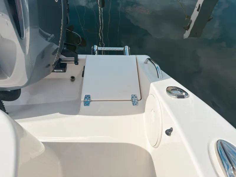 Slide: The Image of 2023 Cobia 280 Center Console boat deck with motor and water reflection. - 13