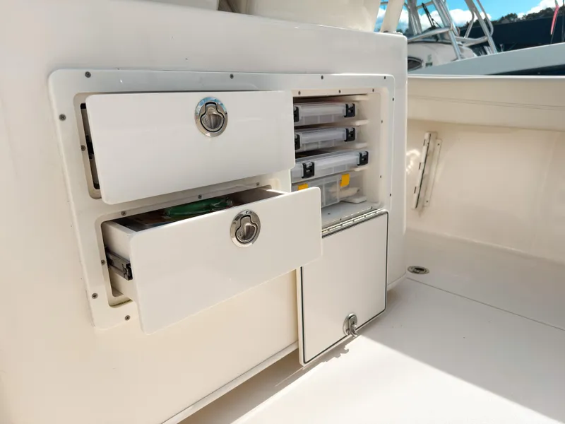 Slide: The Image of 2023 Cobia 280 Center Console storage compartments with open drawers and tackle boxes. - 16
