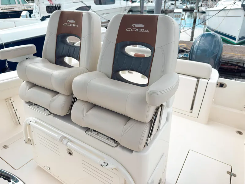 Slide: The Image of 2023 Cobia 280 Center Console boat seats at marina. - 17