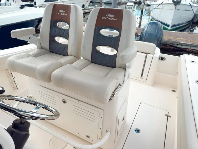 Slide: The Image of 2023 Cobia 280 Center Console boat interior with dual seats and steering wheel. - 18