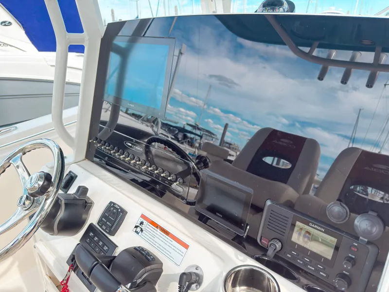 Slide: The Image of 2023 Cobia 280 Center Console dashboard with steering wheel, Garmin display, and control panel. - 19