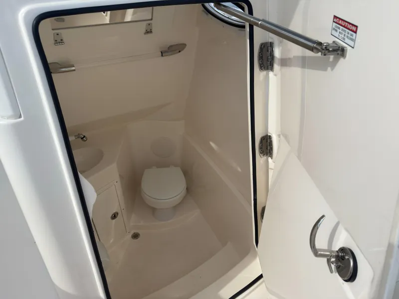 Slide: The Image of Interior view of 2023 Cobia 280 Center Console boat's compact bathroom. - 27