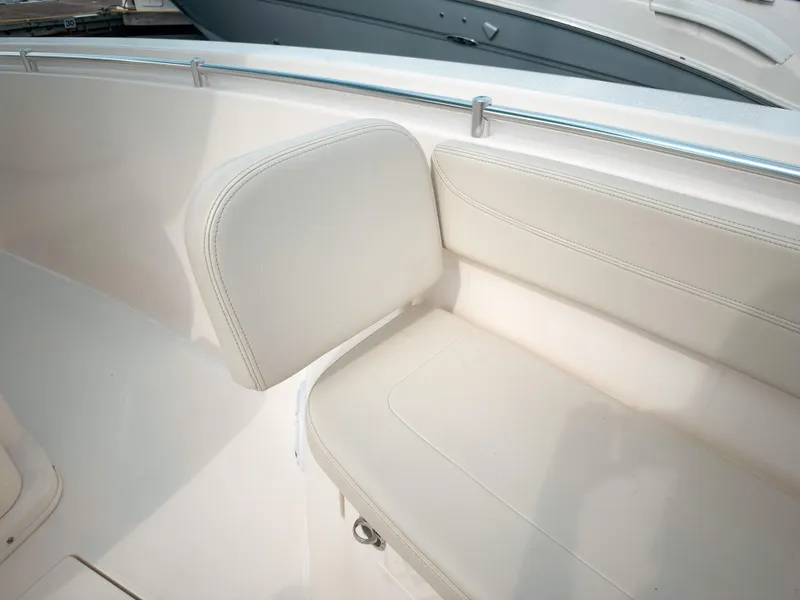 Slide: The Image of 2023 Cobia 280 Center Console boat seating area with white upholstery and stainless steel railing. - 34