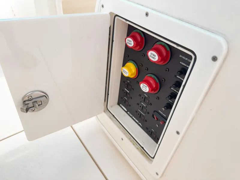 Slide: The Image of Electrical panel on 2023 Cobia 280 Center Console boat with labeled switches and open access door. - 43