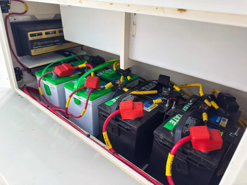 Slide: The Image of Battery compartment of 2023 Cobia 280 Center Console with multiple batteries and wiring. - 44