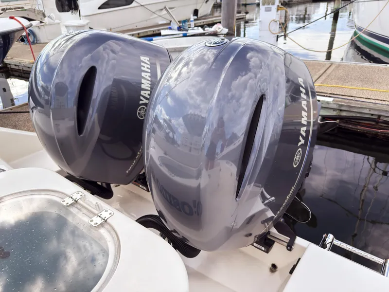 Slide: The Image of Twin Yamaha outboard engines on a 2023 Cobia 280 Center Console boat at a marina. - 5