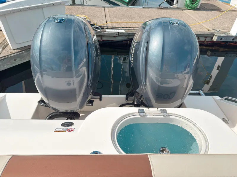 Slide: The Image of 2023 Cobia 280 Center Console with dual Yamaha outboard motors at dock. - 6