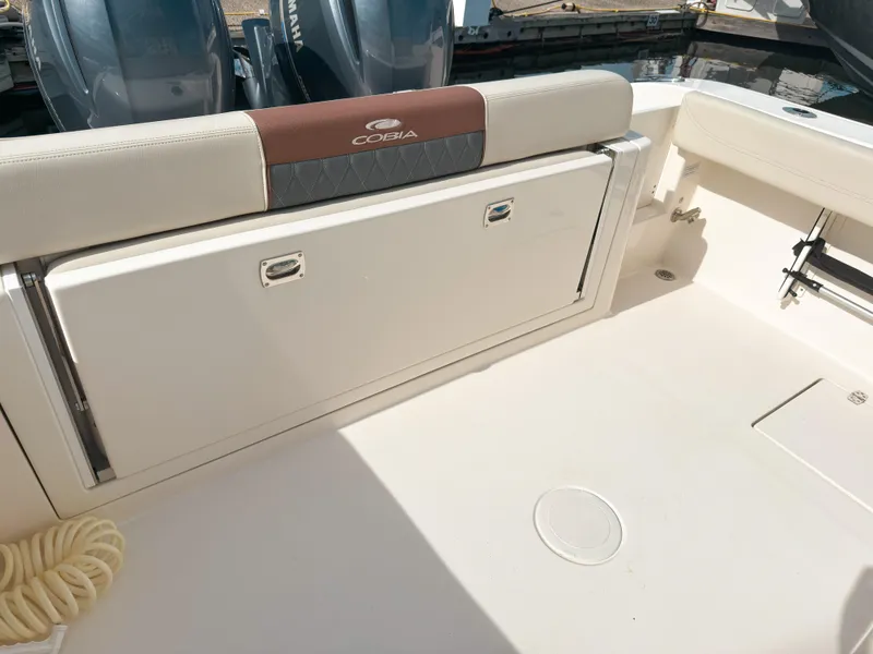 Slide: The Image of 2023 Cobia 280 Center Console boat interior with storage compartment and Yamaha engines. - 9