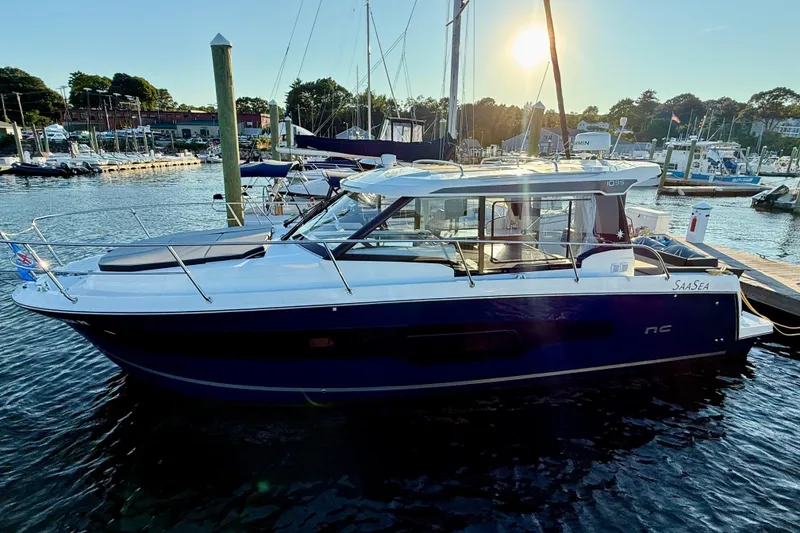 Slide: The Image of 2024 Jeanneau NC 1095 boat docked at marina during sunset. - 11
