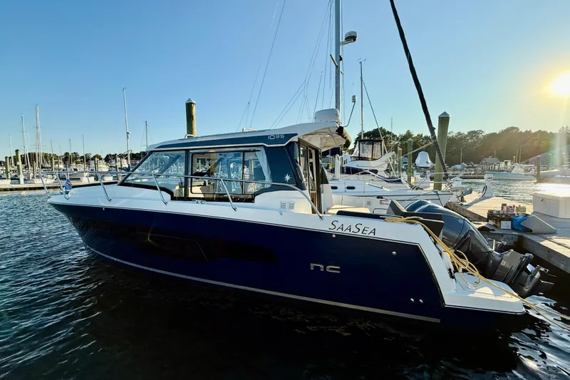 Slide: The Image of 2024 Jeanneau NC 1095 boat docked at marina during sunset. - 12