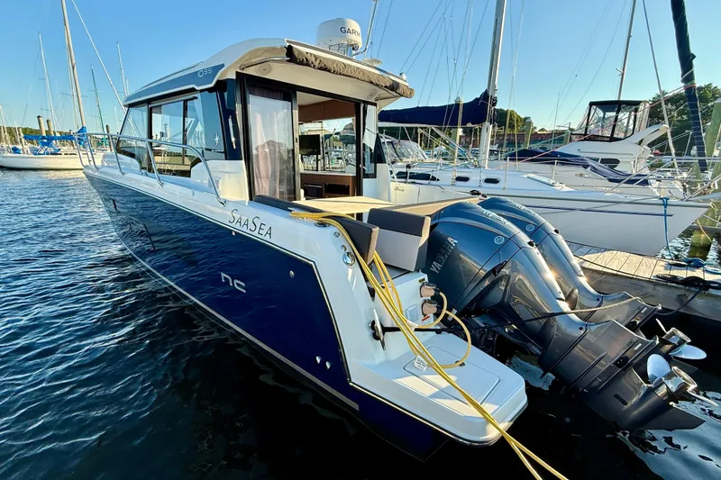 Slide: The Image of 2024 Jeanneau NC 1095 boat docked with dual Yamaha outboard engines. - 13