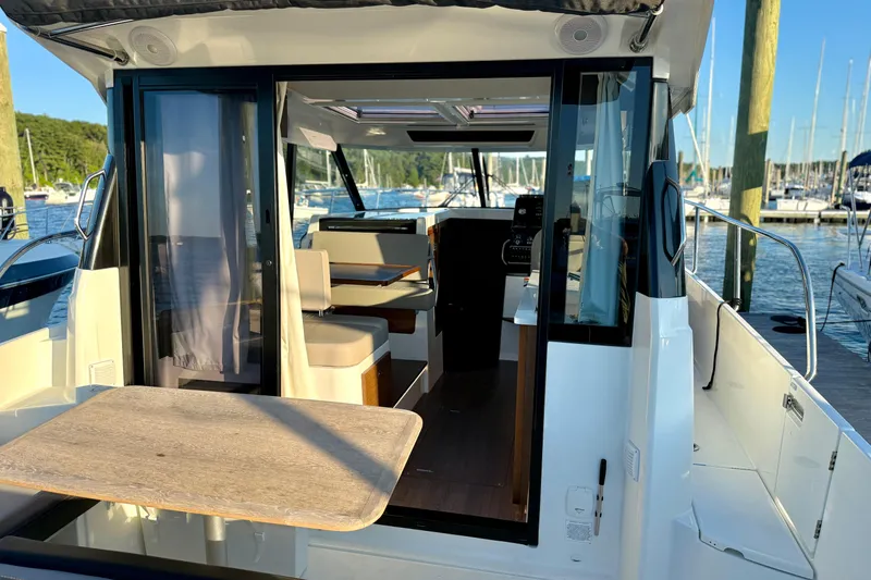 Slide: The Image of 2024 Jeanneau NC 1095 boat interior with seating and table, docked at marina. - 21