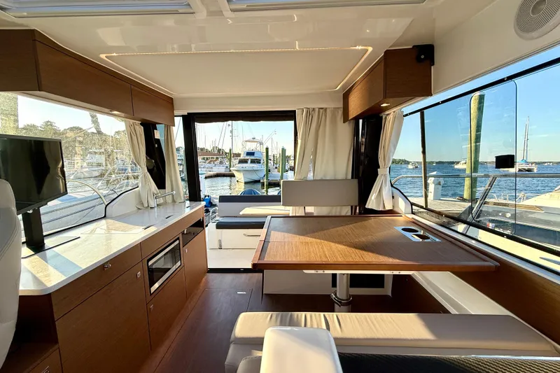Slide: The Image of Interior of 2024 Jeanneau NC 1095 boat with modern kitchen and dining area. - 25