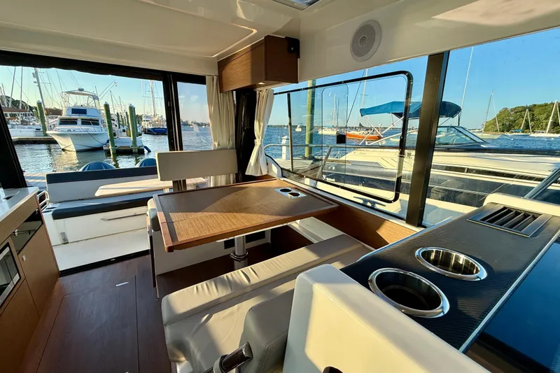 Slide: The Image of Interior of 2024 Jeanneau NC 1095 yacht with dining area and marina view. - 26