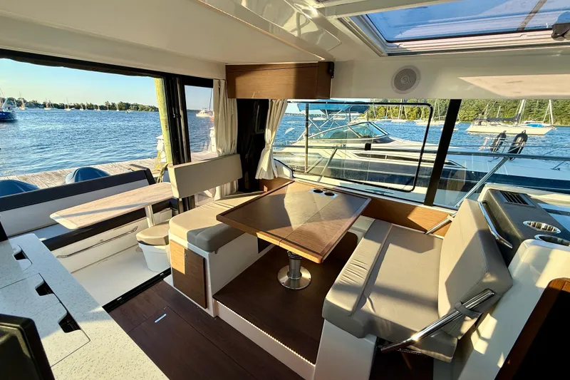 Slide: The Image of Interior of 2024 Jeanneau NC 1095 boat with seating and dining area by the water. - 27
