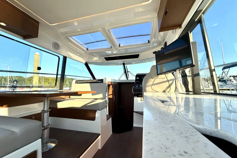 Slide: The Image of Interior of 2024 Jeanneau NC 1095 boat with modern seating and panoramic windows. - 30