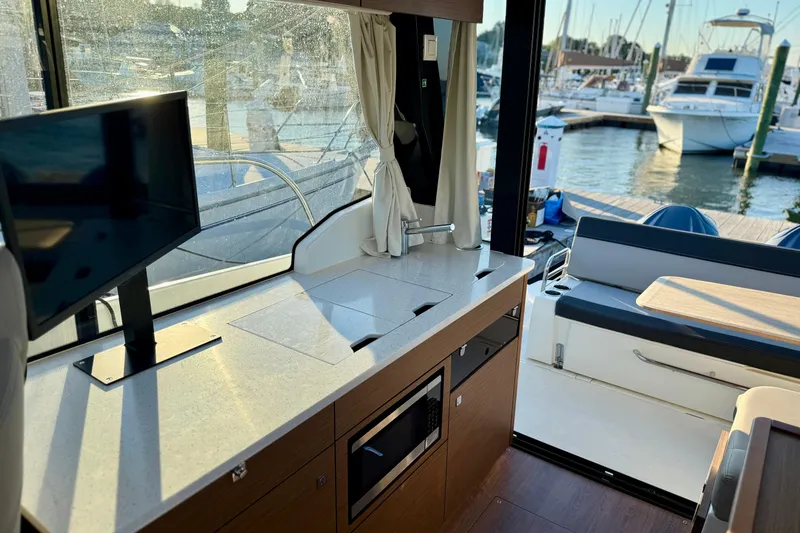 Slide: The Image of Interior of 2024 Jeanneau NC 1095 yacht with modern kitchen and marina view. - 31