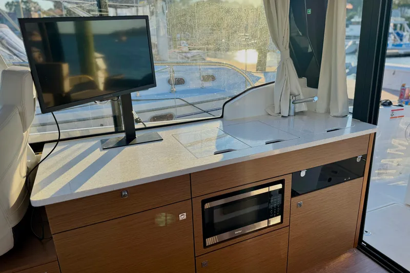 Slide: The Image of Interior of 2024 Jeanneau NC 1095 boat with TV, sink, and microwave. - 32