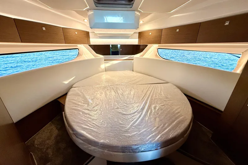 Slide: The Image of Luxurious cabin interior of 2024 Jeanneau NC 1095 with large bed and windows. - 39