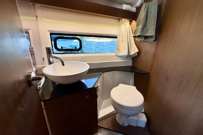 Slide: The Image of 2024 Jeanneau NC 1095 boat bathroom with modern sink, toilet, and window view. - 46