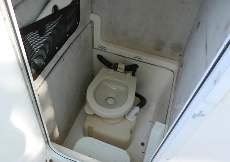 Slide: The Image of 2004 Regulator 26 Forward Seating boat toilet compartment with overhead discharge system. - 13