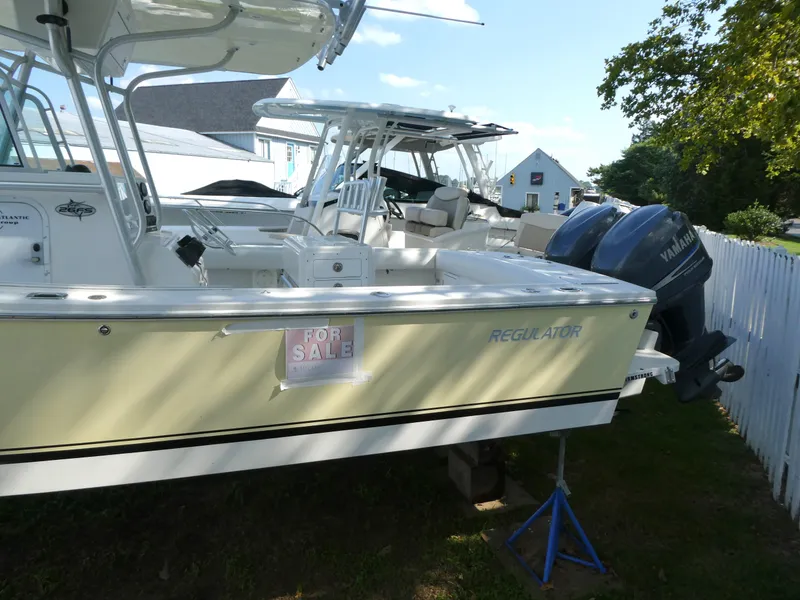 Slide: The Image of 2004 Regulator 26 Forward Seating boat for sale, parked with dual Yamaha engines. - 2