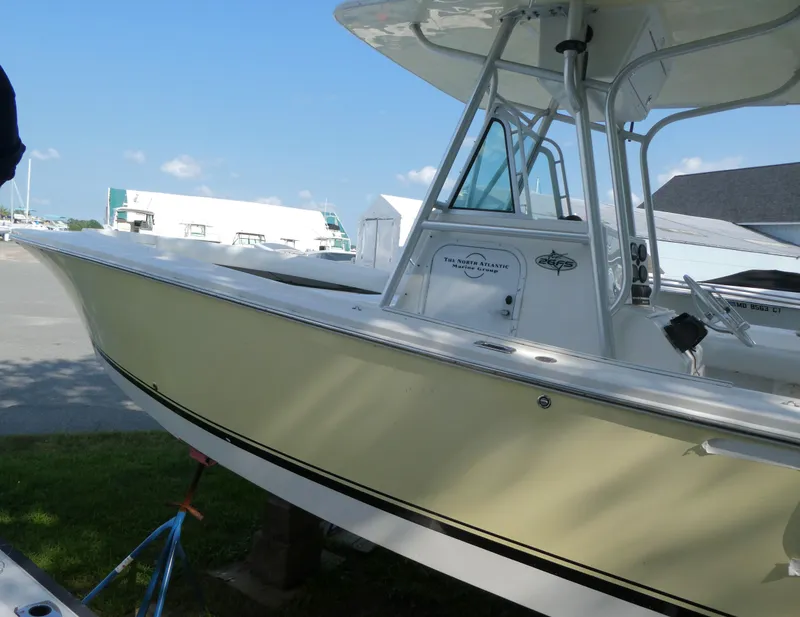 Slide: The Image of 2004 Regulator 26 Forward Seating boat docked under clear blue sky. - 3
