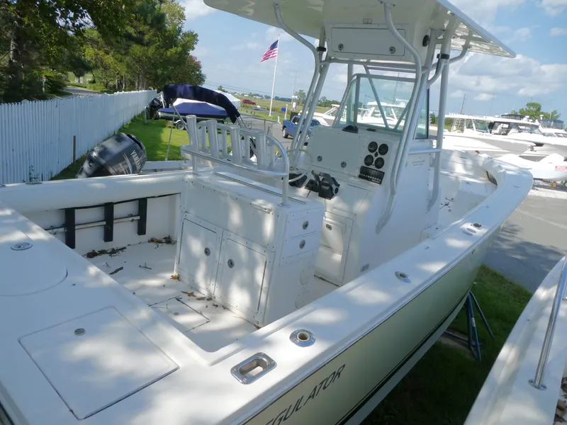 Slide: The Image of 2004 Regulator 26 Forward Seating boat with center console, parked outdoors. - 5