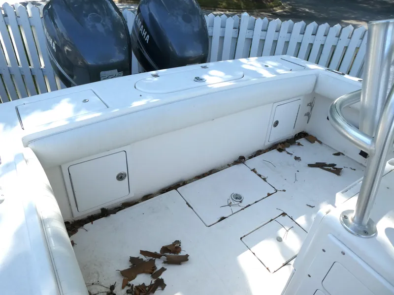 Slide: The Image of 2004 Regulator 26 Forward Seating boat interior with Yamaha engines, leaves scattered on deck. - 6
