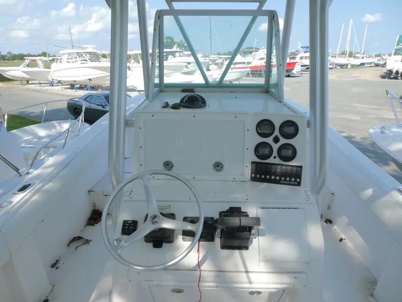 Slide: The Image of 2004 Regulator 26 Forward Seating boat dashboard with steering wheel and gauges. - 8