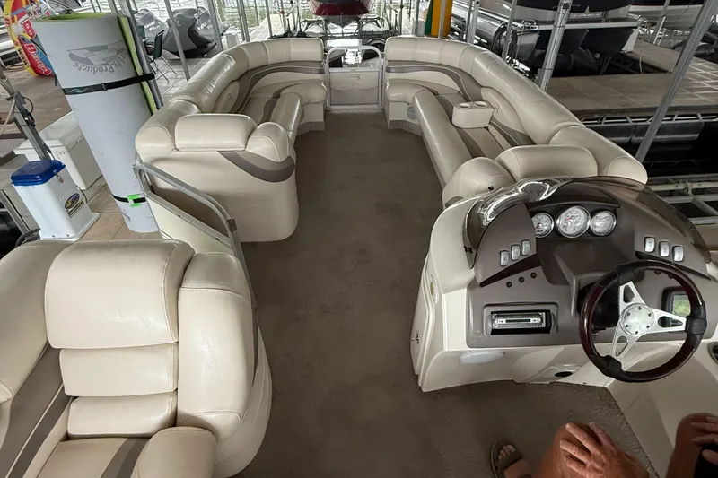 Slide: The Image of 2006 Bennington 2575RL I/O pontoon boat interior with beige seating and control panel. - 10