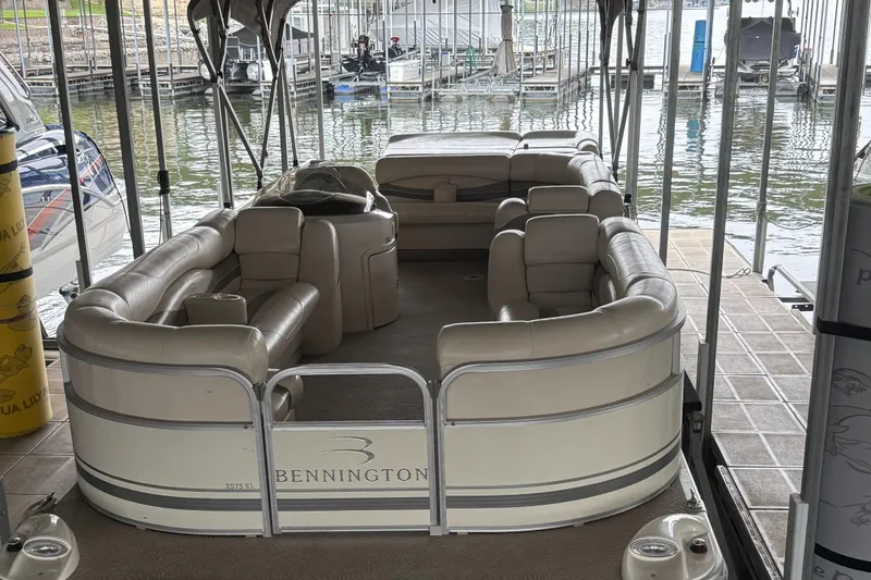 Slide: The Image of 2006 Bennington 2575RL I/O pontoon boat docked, featuring spacious seating and elegant design. - 14