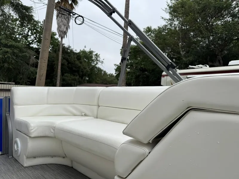 Slide: The Image of 2023 Frontier 24' Cruiser with white leather seating, outdoor setting. - 12