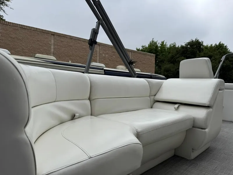 Slide: The Image of 2023 Frontier 24' Cruiser boat with white leather seating, outdoor setting. - 15