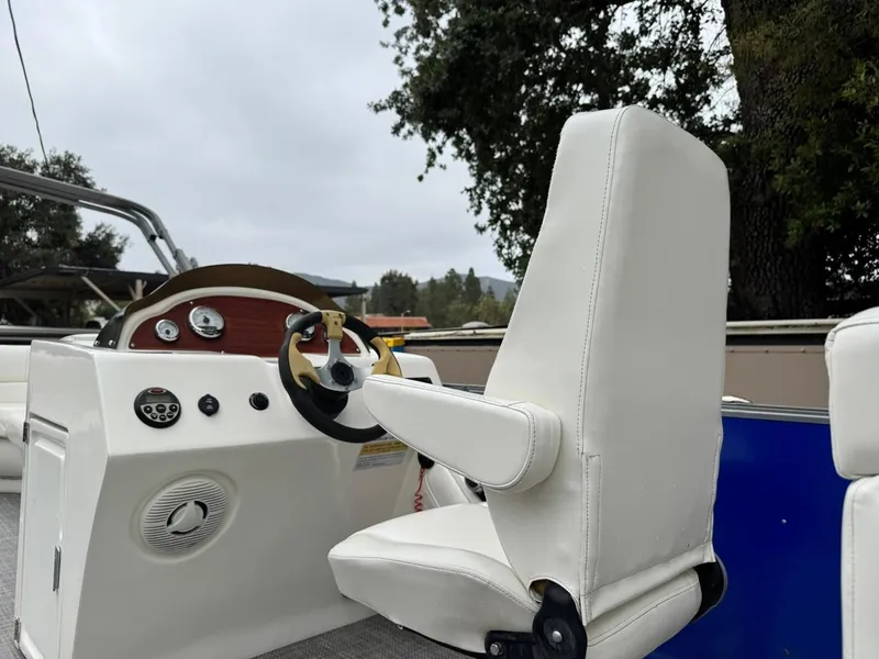 Slide: The Image of 2023 Frontier 24' Cruiser boat interior with steering wheel and white captain's chair. - 17