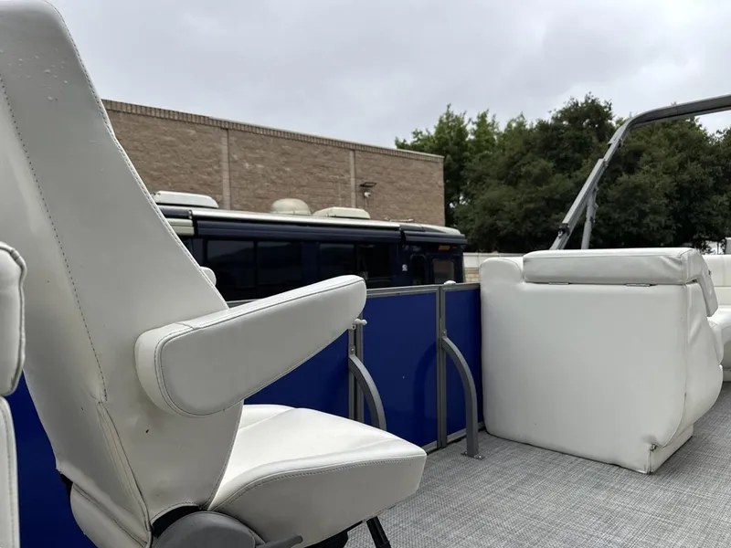 Slide: The Image of 2023 Frontier 24' Cruiser boat interior with white seating and blue accents. - 18