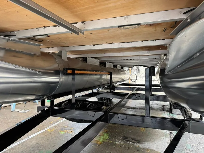 Slide: The Image of Underneath view of 2023 Frontier 24' Cruiser pontoon boat, showcasing aluminum pontoons and frame. - 29