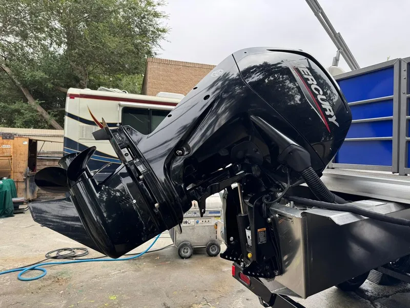 Slide: The Image of 2023 Frontier 24' Cruiser with Mercury outboard motor in a yard setting. - 31