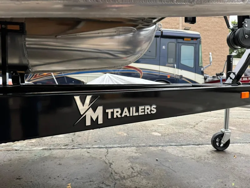 Slide: The Image of Trailer with VM Trailers logo, supporting a 2023 Frontier 24' Cruiser boat. - 36