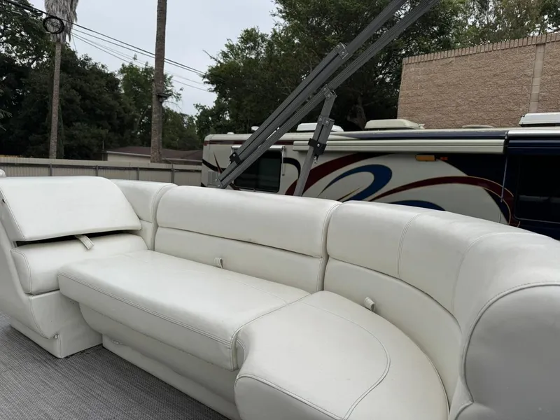 Slide: The Image of 2023 Frontier 24' Cruiser with white leather seating, parked near an RV. - 7