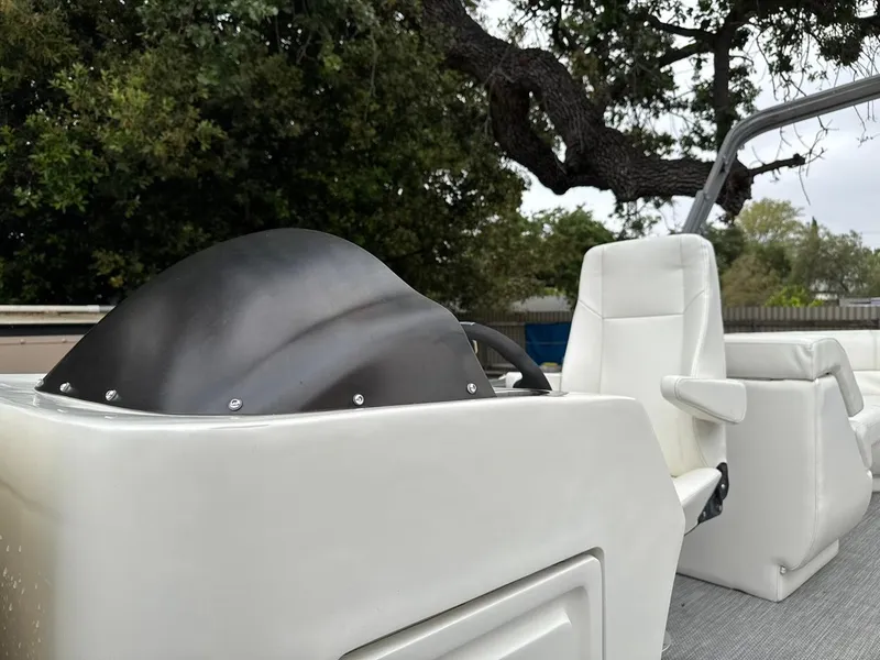 Slide: The Image of 2023 Frontier 24' Cruiser boat interior with white seating and steering console. - 9