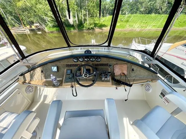 Slide: The Image of 2003 Carver 360 Sport Sedan helm with river view, featuring steering wheel and control panel. - 10