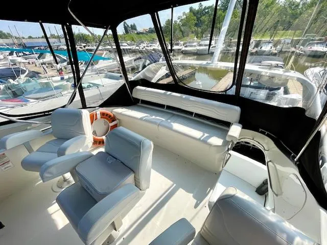 Slide: The Image of 2003 Carver 360 Sport Sedan interior with marina view, featuring comfortable seating and life preserver. - 19