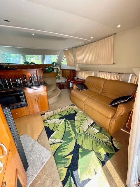 Slide: The Image of 2003 Carver 360 Sport Sedan interior with leather sofa, kitchen, and tropical rug. - 21