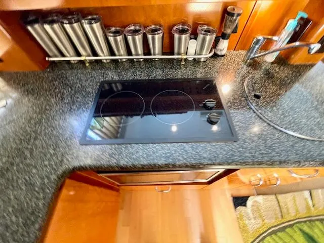 Slide: The Image of 2003 Carver 360 Sport Sedan kitchen with stovetop, spice rack, and sink. - 26