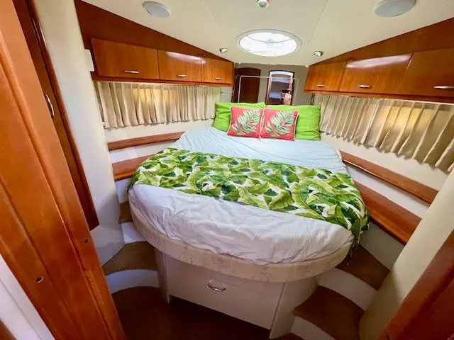 Slide: The Image of 2003 Carver 360 Sport Sedan bedroom with tropical decor and wooden cabinetry. - 32