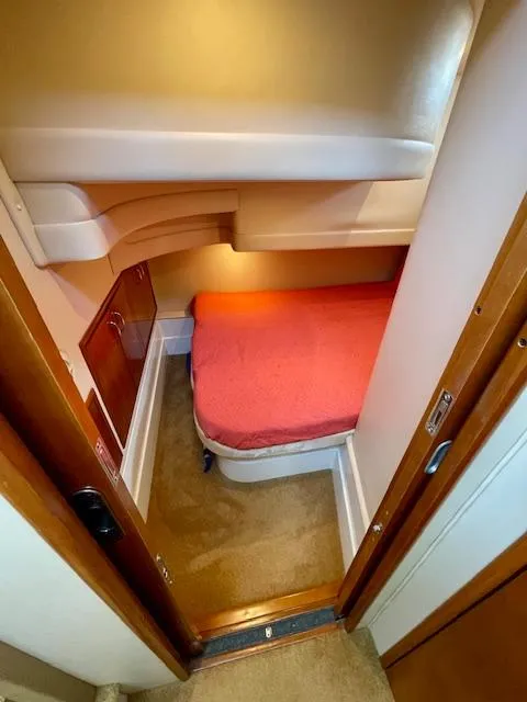 Slide: The Image of Cozy cabin interior of 2003 Carver 360 Sport Sedan with red bedding and wood accents. - 37