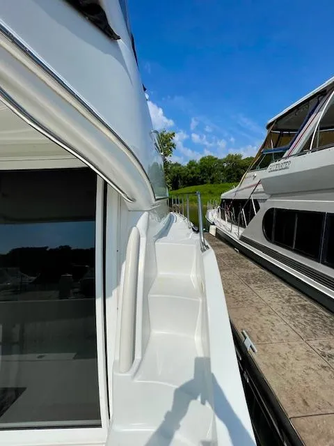 Slide: The Image of 2003 Carver 360 Sport Sedan docked, showcasing sleek design and sunny weather. - 8