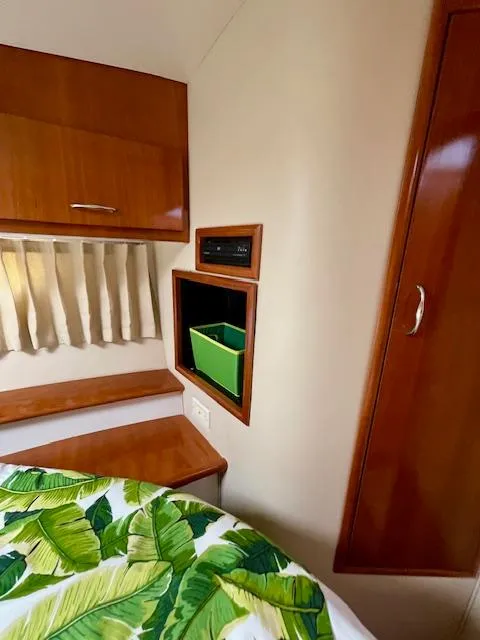 Slide: The Image of Interior of 2003 Carver 360 Sport Sedan with wood cabinetry and tropical bedding. - 33